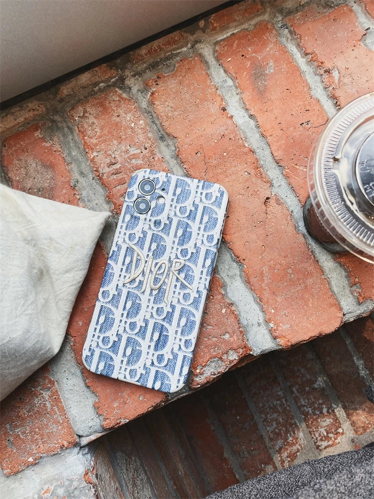 Blaue Dior-Stickerei mit iPhone-Hüllen aus Stoff mit goldenem Logo.