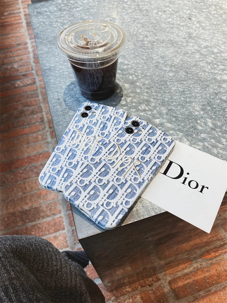 Blaue Dior-Stickerei mit iPhone-Hüllen aus Stoff mit goldenem Logo.